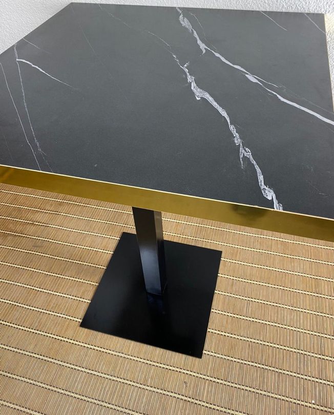 mesa imitación mármol negro con canto dorado y pie negro