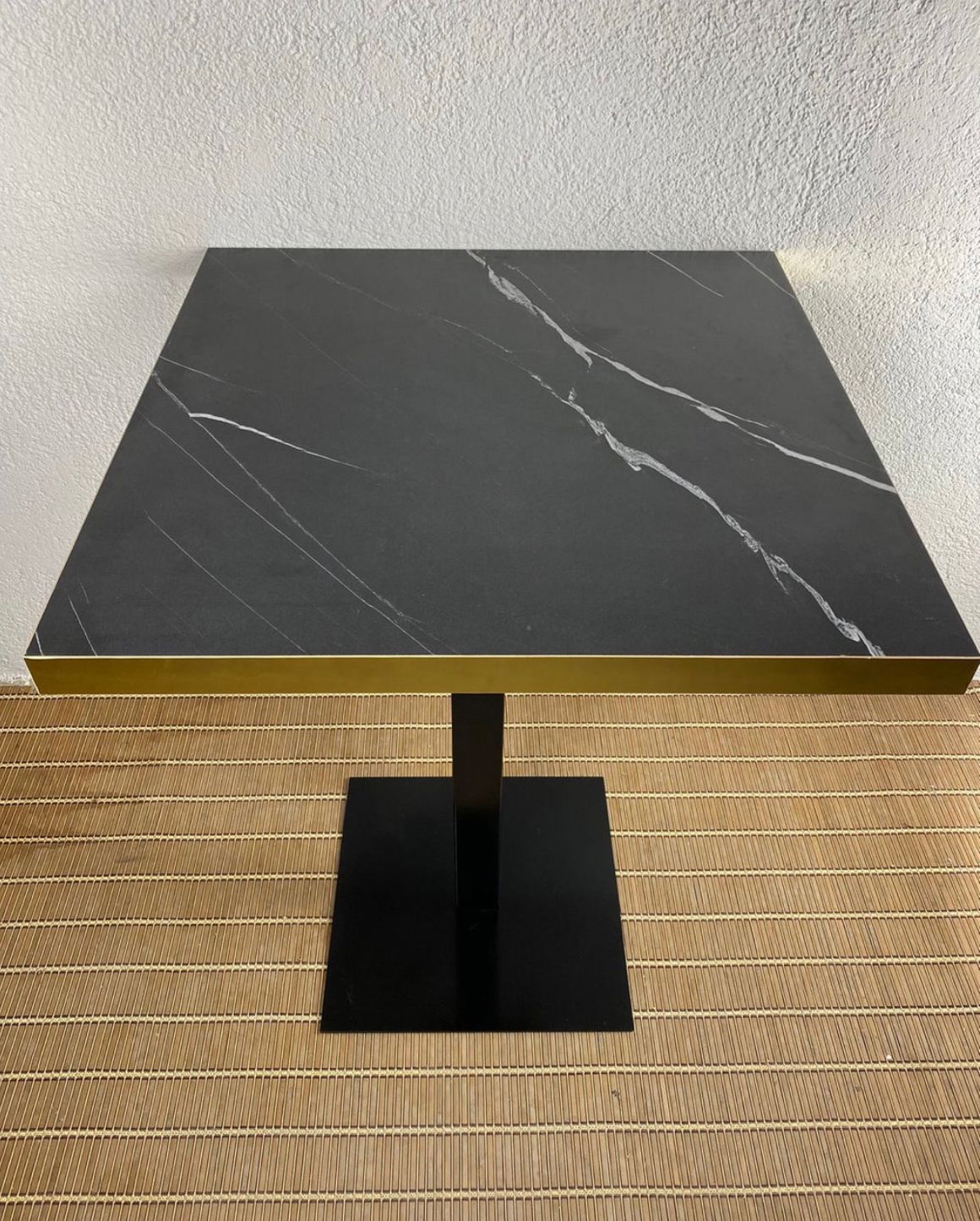 mesa imitación mármol negro con canto dorado y pie negro