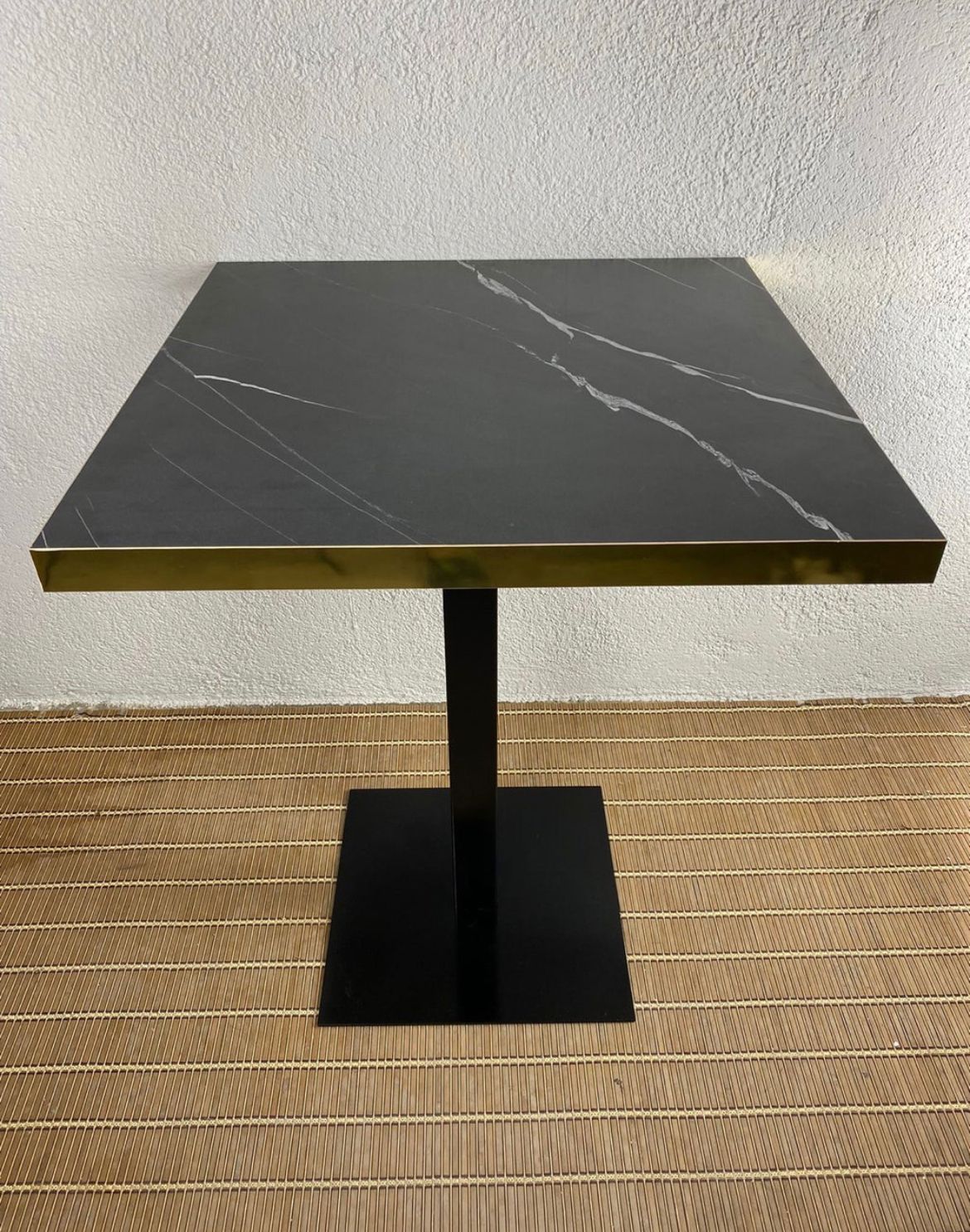 mesa imitación mármol negro con canto dorado y pie negro