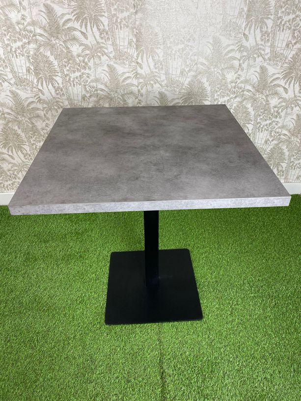 mesa estilo gris cemento con pie de hierro color negro