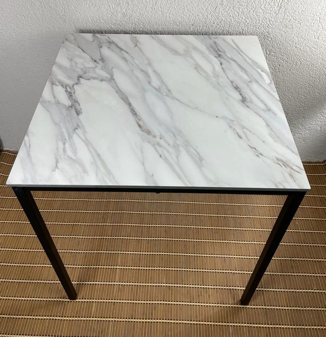 mesa de exterior apilable con tablero tipo mármol blanco