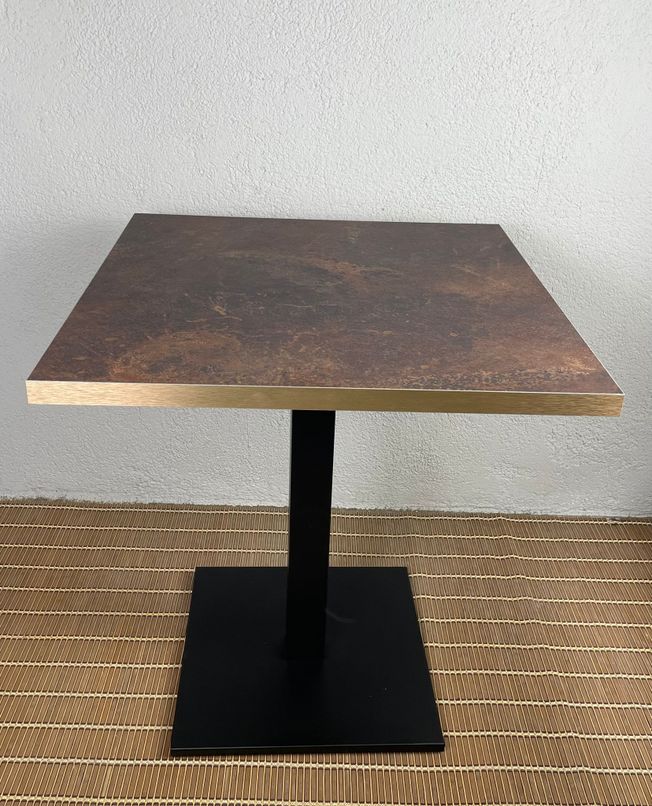 mesa con tablero tipo óxido y pie negro