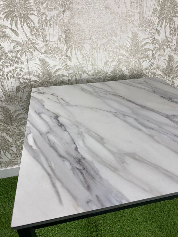 mesa de exterior apilable con tablero tipo mármol blanco