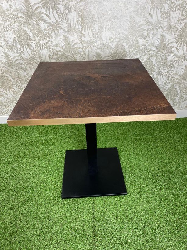 mesa con tablero tipo óxido y pie negro