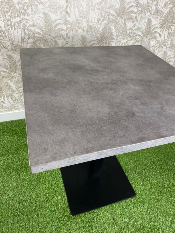 mesa estilo gris cemento con pie de hierro color negro